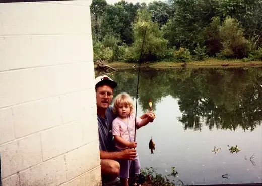 Fishing at the edge of a still pond